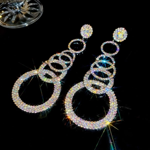 Detailed macro view of cascading colorful rhinestone round tassel drop earrings on black