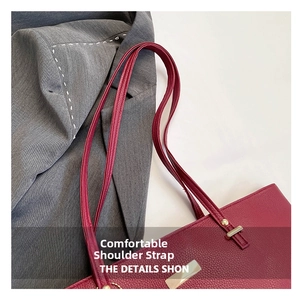 Close-up of burgundy lychee grain leather tote bag with reinforced straps and gold hardware