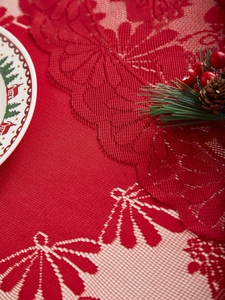 Macro shot of red lace festive table runner with floral patterns and Christmas decor