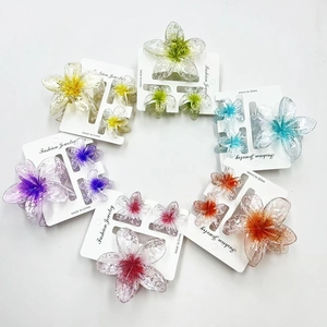 Close-up of translucent frangipani flower hair claw set in vibrant assorted colors and sizes