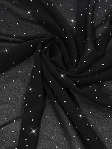 Detailed macro view of black chiffon fabric featuring sparkling star-patterned rhinestones