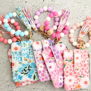 Macro detail of floral card holders with matching silicone bead wristlets and tassels