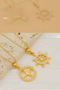 Macro detail of gold-plated ship wheel and nautical compass pendants with white zircon inlays