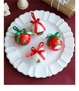 Detail of red and white Christmas foam balls with festive prints and silk bow hangers