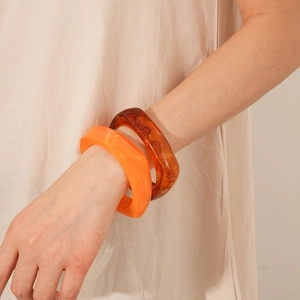 Detail of resin geometric square bangle in vibrant orange and amber texture