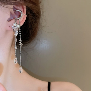 Detail of silver moon ear cuff with sparkling rhinestones, long tassels and pearls