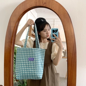 Detailed macro view of the blue and white checkered wool tote bag with purple label