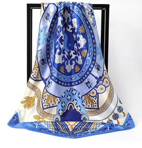 Close-up of mandala patterns and golden leaf motifs on blue satin silk scarf