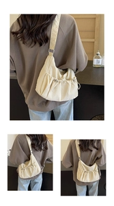 Macro detail of creamy nylon crossbody bag featuring drawstring pleated texture and strap