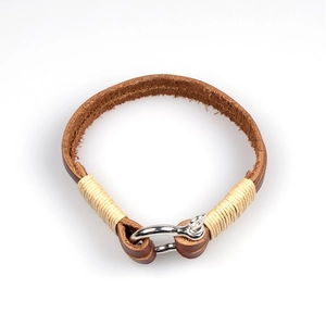 Vintage brown woven leather bracelet with silver horseshoe clasp on white background