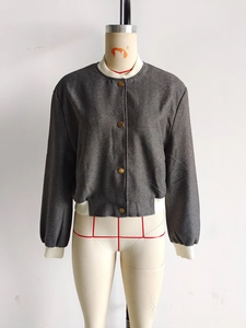 Detailed view of dark grey bomber jacket featuring vintage gold buttons and ribbed trims