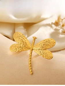 Detailed close-up of golden dragonfly ring featuring hammered texture wing on silk