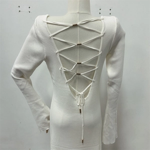 Detail view of the backless knitted dress with metallic buckles and criss-cross tie straps