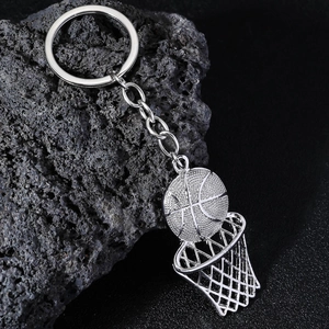 Silver basketball and hoop keychain with realistic metal texture on volcanic rock