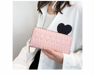 Detailed close-up of a pink long zipper wallet featuring a stylish quilted diamond pattern