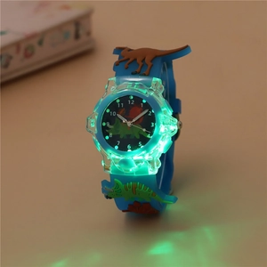 Glow-in-the-dark detail of kids blue silicone watch with 3D dinosaur relief and green LED light