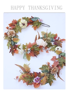 Detail of autumn wreath with maple leaves, white pumpkins and Happy Thanksgiving sign