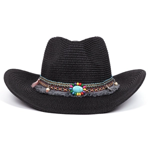 Detail of black straw fedora featuring ethnic beads, turquoise stone and pink tassels