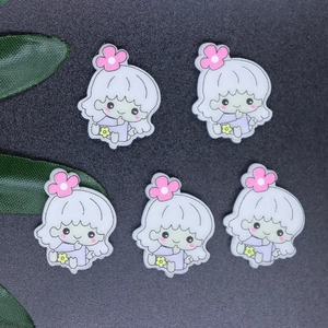 Flat lay of five resin cartoon girl figurines with pink flowers and purple dresses