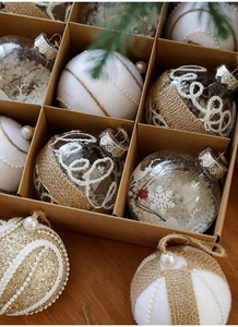 Close-up of assorted 8cm Christmas balls with snowflakes and pearls in a craft paper box