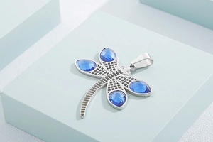 Detailed view of dragonfly pendant with silver plating and faceted blue crystals