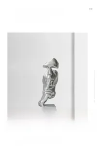 Detail of silver Silence is Golden sculpture with matte finish and rectangular base