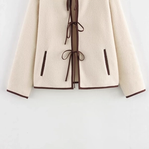 Giacca da donna in pile bianco sporco con bordo marrone e tre fiocchi decorativi