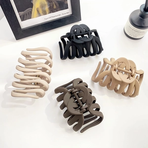 Set of four matte large pumpkin hair claws in neutral earth tones on white background