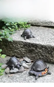 Detailed macro view of vintage cast iron turtle storage boxes with textured shell lids