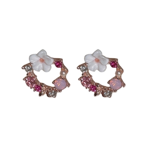 Eleganti orecchini a fiore traforato oro rosa con cristalli rosa e perle su sfondo bianco