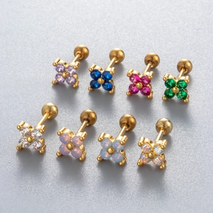 Detailed macro view of gold clover stud earrings with opal and colorful gemstones
