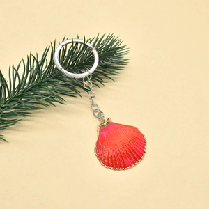 Detail of bohemian red shell pendant with gold edges on beach style keychain