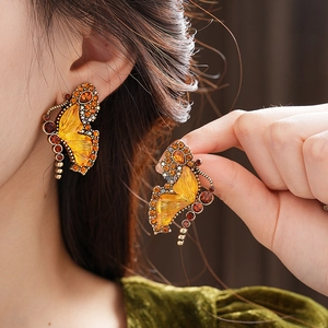 Close-up of vintage butterfly earrings with amber crystals and bronze metal base