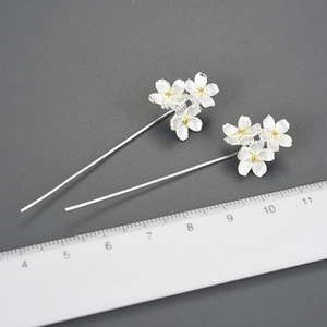 Macro shot of S925 sterling silver forget-me-not drop earrings with textured petals