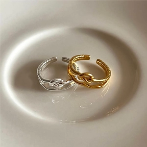 Elegant 925 sterling silver twisted knot rings in gold and silver finish on ceramic tray
