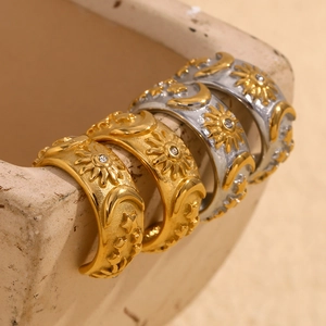 Macro detail of sun moon and star engraved rings with rhinestones on beige ceramic