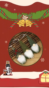 Three green knitted Christmas gnomes with elk patterns and white ribbons for hanging