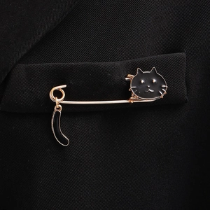 Cute black enamel cat brooch with swinging tail pinned on a black suit pocket jacket