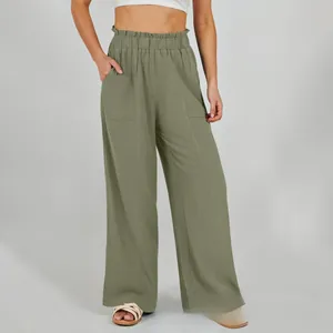 Dettaglio dei pantaloni in lino verde oliva a vita alta con vita a sacchetto e tasche laterali