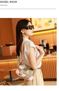 Detail of color-block underarm bag featuring pink leather trim and geometric patterns