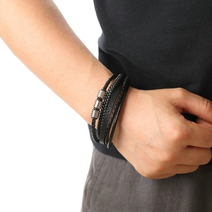 Close-up of a multi-layer black braided leather bracelet with stainless steel rings