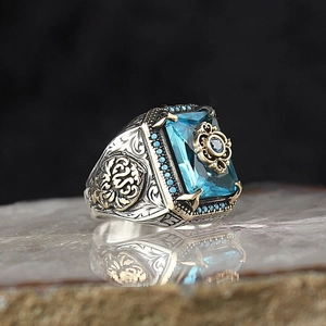 Macro detail of retro engraved ring featuring a blue gemstone and golden accents