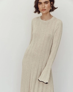 Détail de la robe en maille beige avec d'élégantes bordures noires contrastées aux poignets