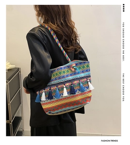 Ethnic style woven tote bag featuring colorful geometric patterns and blue silk tassels