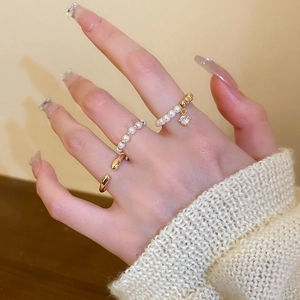 Detailed shot of a 3-piece ring set with gold plating, cubic zirconia, and white pearls