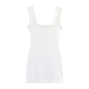 Detailed view of white ribbed knit dress with ruffled edges and pearl embellishments