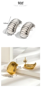 Macro detail of silver and gold shell earrings with vertical textured relief patterns