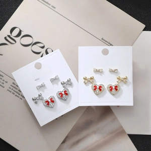 Macro shot of S925 silver stud earrings set featuring red hearts and crystal bows
