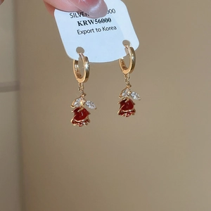 Detailed macro view of handmade red enamel rose earrings with marquise zircon leaves