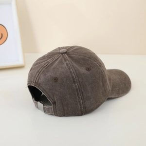 Detail of adjustable metal buckle and dark brown corduroy texture on kids baseball cap